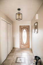 Entryway featuring a textured ceiling and baseboards