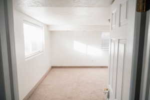 Spare room with light colored carpet and a textured ceiling