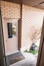 Entrance to property featuring brick siding