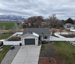 Single story home with a garage, driveway, a mountain view, and a gate