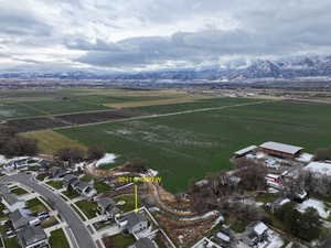 Aerial overview of property's location with rows of crops, rural landscape, and a mountain backdrop