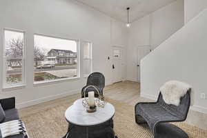 Living area featuring a high ceiling and light wood-style flooring
