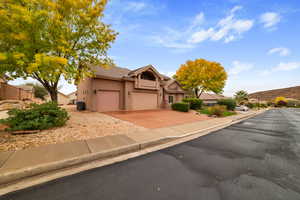 View of front facade featuring driveway, a tiled roof, stucco siding, and a garage