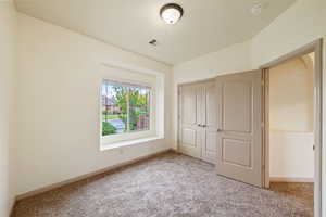 Unfurnished bedroom with light colored carpet and a closet