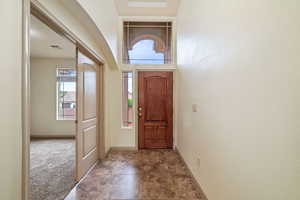 Foyer with baseboards and carpet flooring