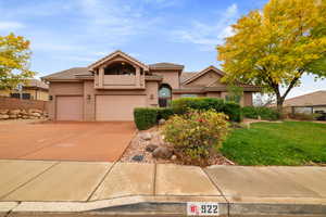 View of front of home featuring driveway, stucco siding, a tile roof, and a front yard