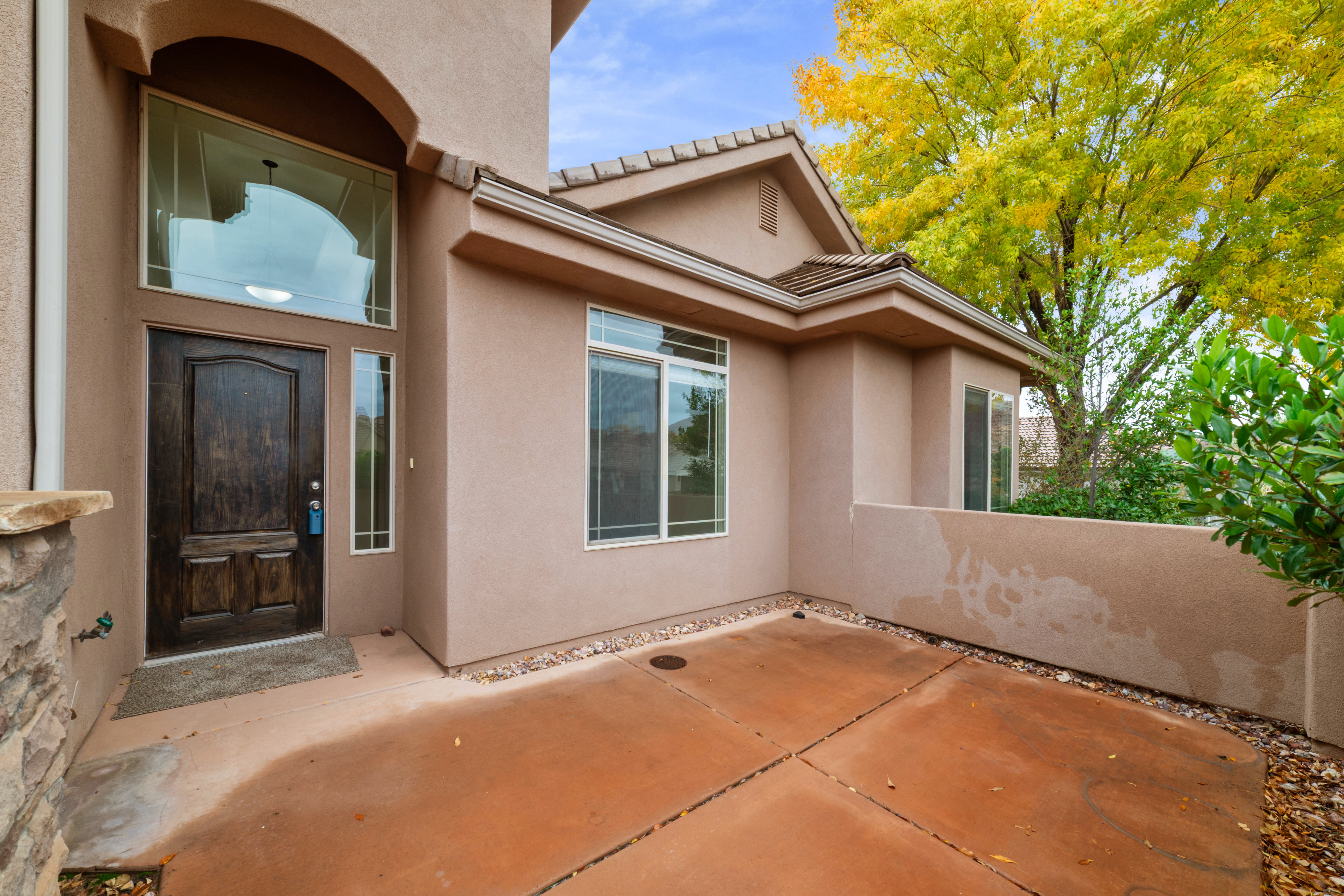 View of exterior entry featuring stucco siding, a patio, and a tiled roof