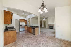Kitchen with arched walkways, decorative light fixtures, a chandelier, appliances with stainless steel finishes, and open floor plan