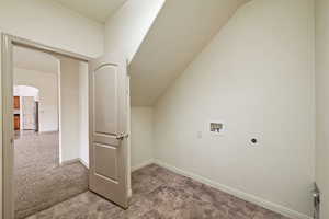 Laundry room featuring hookup for a washing machine, arched walkways, carpet flooring, and vaulted ceiling