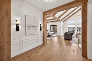 Hallway with light wood finished floors, a decorative wall, a chandelier, and recessed lighting