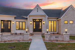 View of front facade with a shingled roof, a front lawn, and brick siding