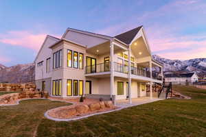 Back of property featuring a mountain view, stairway, and a yard
