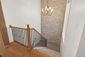 Staircase featuring a chandelier