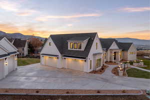 Modern inspired farmhouse featuring driveway, roof with shingles, a front yard, and a mountain view