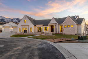Modern inspired farmhouse featuring a front lawn, concrete driveway, and a shingled roof