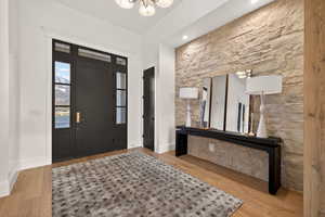 Entryway with light wood-style floors and a chandelier