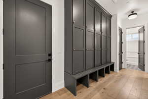 Mudroom featuring light wood-style flooring and baseboards