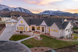 Modern farmhouse with a mountain view, stone siding, and a yard