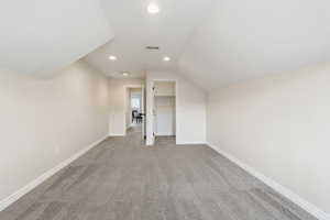 Bonus room with lofted ceiling, recessed lighting, and light colored carpet