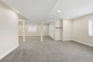Below grade area with light carpet and recessed lighting