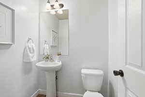 Half bathroom featuring toilet and baseboards