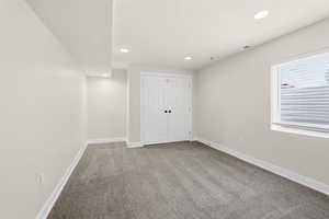Unfurnished bedroom featuring light colored carpet, recessed lighting, and a closet