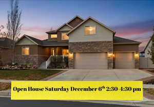 View of front of property featuring stone siding, concrete driveway, an attached garage, and a porch