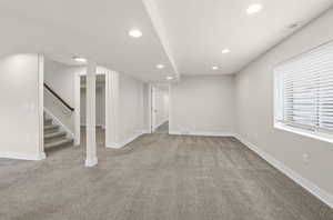 Below grade area featuring stairway, recessed lighting, and light carpet