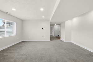 Spare room with recessed lighting, light colored carpet, and a textured ceiling