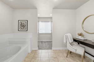 Bathroom with recessed lighting, a garden tub, and light tile patterned floors