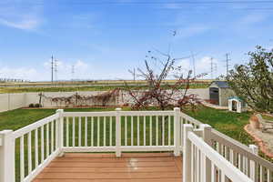 Deck featuring a fenced backyard and a storage unit