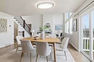 Dining space with light wood-type flooring and stairs