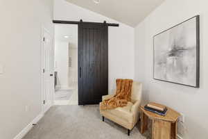Sitting room featuring a barn door, light carpet, recessed lighting, lofted ceiling, and light tile patterned flooring