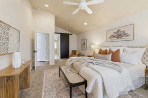 Bedroom with a barn door, light carpet, recessed lighting, a ceiling fan, and high vaulted ceiling