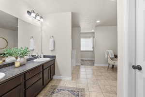 Bathroom with double vanity, light tile patterned floors, and recessed lighting
