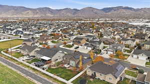 Aerial view of property and surrounding area featuring nearby suburban area and a mountainous background