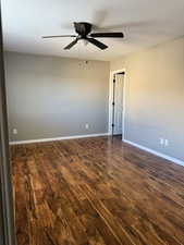 Spare room with dark wood finished floors and a ceiling fan