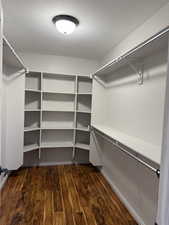 Walk in closet featuring dark wood finished floors