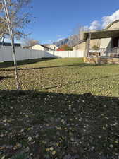 Fenced backyard featuring a deck with mountain view
