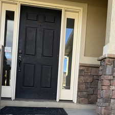 Property entrance featuring stucco siding and stone siding
