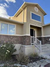View of front of property featuring stone siding and stucco siding