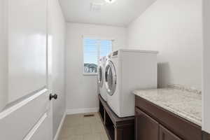 Laundry room with light tile patterned floors and separate washer and dryer