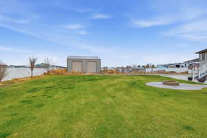 View of yard featuring a fire pit, a patio area, and an outdoor structure