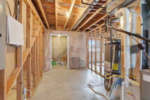 Basement featuring secured water heater and electric panel