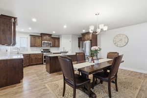 Dining room featuring a chandelier, light wood-style flooring, and recessed lighting