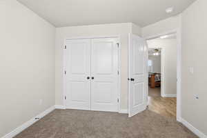 Unfurnished bedroom featuring carpet and a closet