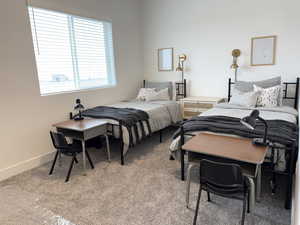 Bedroom featuring light carpet and baseboards