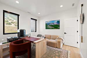 Office space featuring light wood-style floors and recessed lighting