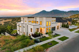 Contemporary home with concrete driveway, stucco siding, a garage, and a mountain view