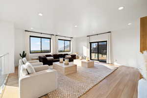 Living area with light wood-style floors, healthy amount of natural light, and recessed lighting